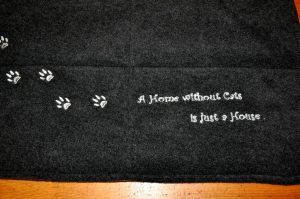 CARIS-Naehwerkstatt - Katzendecke mit Schriftzug und Tatzenspur